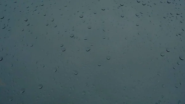Regendruppels Die Naar Beneden Lopen Een Glazen Raam Donkerblauwe Achtergrond — Stockfoto
