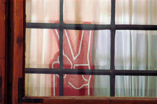 Czerwony Znak Zwycięstwa Szklanym Oknem Kratami — Zdjęcie stockowe