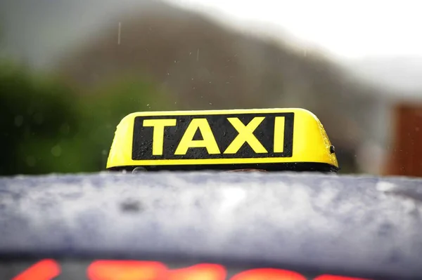 車の屋根の上に黄色と黒のタクシー標識 — ストック写真