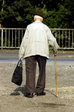 Bastonlu yaşlı adam sokaklarda yürüyor.