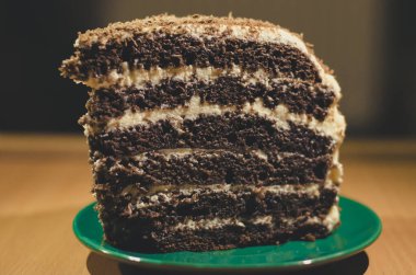 Bir dilim çikolatalı kek yeşil bir fincan tabağında