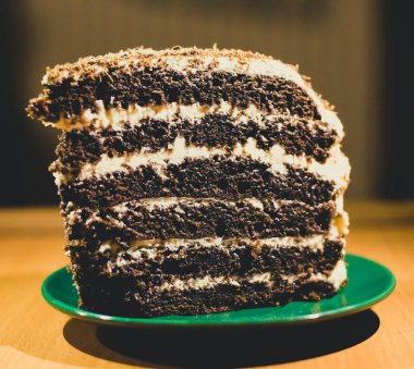 Bir dilim çikolatalı kek yeşil bir fincan tabağında