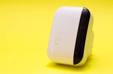 Wireless wifi repeater on yellow background close-up clipart