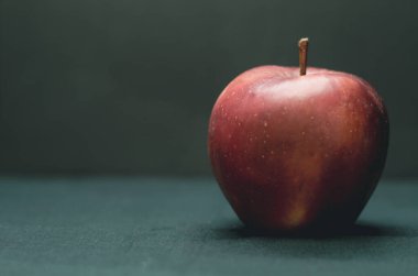 Koyu arkaplanda güzel bir kırmızı elma. Koyu arkaplanda meyveler. Kırmızı elma yaklaş..