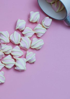 Şekerlemeler bir fincandan dökülüyor. Ametist renk arkaplanı