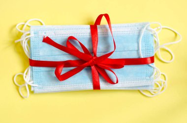 Sarı arka planda tıbbi antiviral maskeler. Coronavirus koruması. Virüslerle savaşmak için bir hediye.