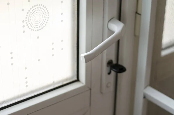 Part of a plastic door. The key is inserted in the door lock. Real estate purchase and sale concept. Front door window