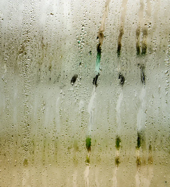 Indoor wet window on which droplets of water slide