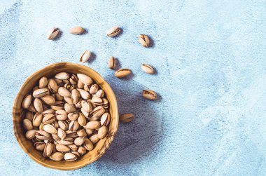 Çam fıstığı. Beton arka planda kahverengi bir kasede fıstıklı fıstık. Sağlıklı yeme kavramı