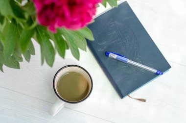 Defter, kalem, kahve ve çiçek. Evde eğitim kavramı. İç mekan ve konfor.