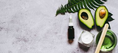 İki parça avokado, krema, avokado yağı ve eğreltiotu yaprağı. Doğal Organik Ürün Güzellik Konsepti. Cilt bakımı, vücut bakımı.