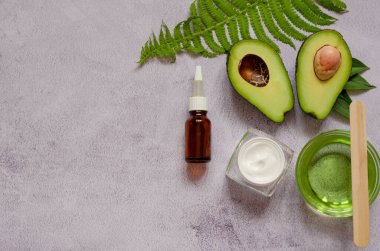 İki parça avokado, avokado yağı, eğrelti otu yaprağı ve masaj taşı. Doğal Organik Ürün Güzellik Konsepti.