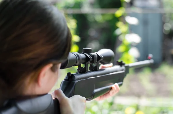 Keskin nişancı kız elinde silah tutuyor. Avcı dikiz aynasından optik görüntüye bakıyor. Pnömatik silah. Keskin nişancı tüfeğinin dürbününe bakar.