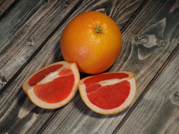 Juicy ripe red grapefruit on a wooden background