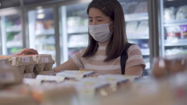 Mladá Asijská Žena Bílé Lékařské Masce Při Pohledu Vejce Regál — Stock video
