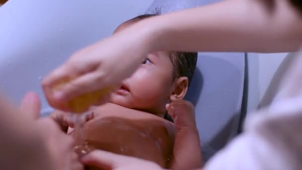 亚洲父母给婴儿洗澡时和在家里 宝宝洗澡时 温暖快乐 洗发水和肥皂 荧光灯 — 图库视频影像