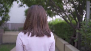 Yavaş çekimde maske takan Asyalı kadın parkta dönüyor, siyah kısa saçlı genç model, mutlu yaşam tarzları, covid19 Corona virüsü, virüs yayıyor hastalık, sağlık sigortası konsepti, ön görüş, 1080p