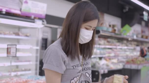 Jovem Asiática Feminina Vestindo Máscara Dobrar Olhando Para Alimentos Mercearia — Vídeo de Stock