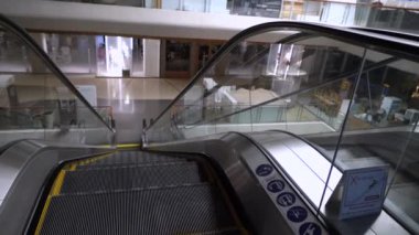 Boş yürüyen merdiven aşağı bakıyor, alışveriş merkezinde müşteri yok, COVID19 'un kapalı mağaza efekti - Corona virüsü, mimari boş yer, para ekonomisi krizi, 