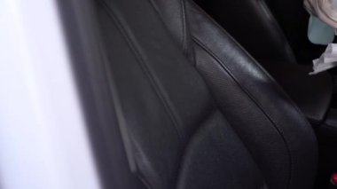 Beyaz eldivenli el spreyleme ve cam yüzeyi silme, arabanın ön camını silme, dezenfektan bezi, Covid-19 Corona virüsü, araba bakımı, anti bakteri, hijyen yaşam tarzı, sabah ışığı.