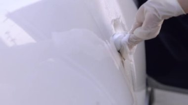 Beyaz eldivenli kadın sprey sıkar ve kapı kolunu siler, araba sterilize eder, beyaz sedan araba, alkol temizliği, hastalık önleme, Covid19 Corona virüsü salgınını önler, araba yıkama, modern yaşam tarzı. 