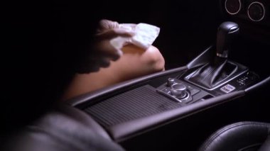 Beyaz eldivenli el spreyleme ve cam yüzeyi silme, arabanın ön camını silme, dezenfektan bezi, Covid-19 Corona virüsü, araba bakımı, anti bakteri, hijyen yaşam tarzı, sabah ışığı.