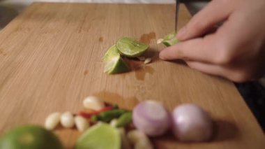 Ev mutfağındaki ahşap kesim tahtasından limon toplayan kadın eli kapama, ev yemeği, geceleri yemek malzemeleri baharat pişirme, gizli Asya tarifi mutfağı. yemek reklamı, ekşi sıcak ve baharatlı