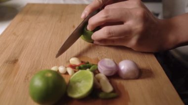 Ev mutfağında ahşap kesim tahtasına limon dilimleyen kadın eli, ev yemeği, geceleri yemek malzemeleri, baharatlar lezzetli baharatlar, aile yemeği, gizli Asya tarifi mutfağı.