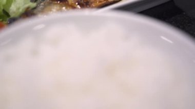 4k Japon tarif seti menüsü, öğle yemeği zamanı, ızgara balık uskumrusunu beyaz tabakta kapayın, Asya mutfağı, ev yemeği, vitamin omega üç, floresan ışık, siyah masa, yeşil sebze, sol slayt