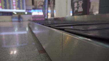 Terminaldeki Varış Salonunda hareket eden bir elektronik bagaj bandı, hava ulaşımının son durağı, yolcu ayrıcalıkları servisi, uluslararası seyahat, ait olunan dağıtımda personel yardımı