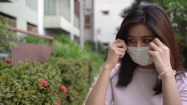 4K Asyalı genç bayan beyaz cerrahi maske taktı. Normal hayata geri dönmeyi umut ediyorum, sağlık hizmetleri PM2.5, virüs covid19, küresel sorunlar, ortaya çıkan model yüz, kısa siyah saçlar, tek başına ayakta durmak