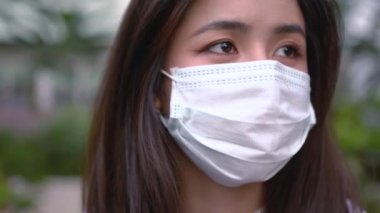 4K Asyalı koruyucu maske takan genç bir kadın. Hope motivasyon sahnesi, sağlık konsepti, virüs covid19, küresel meseleler, bokeh bulanık arkaplan, yörüngedeki kamera ön görünümü