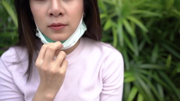 4Kアジアの若い女性は自分自身を保護するためにマスクを着用危険な病気や大気汚染 緑の葉や茂みの背景 Covid19コロナウイルス ウイルス拡散防止 医療概念を形成します — ストック動画