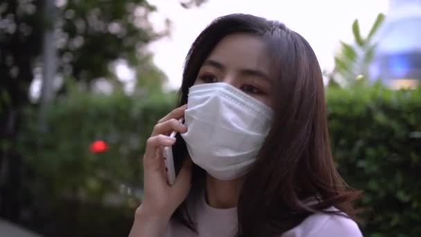 4Kアジアの若い女性はマスクを身に着けている携帯電話で話す 世界のパンデミック 大気汚染 コロナウイルスCovid 健康上の懸念 スマートライフ自己隔離 社会的距離 隔離されたまま 年2020 — ストック動画