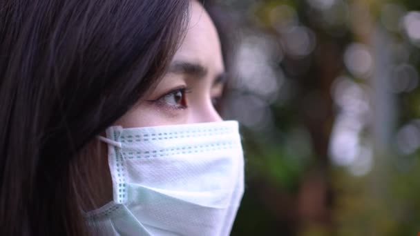 4K若いかわいいアジアの女性はマスクを着用思考アクションを見て 人間の希望のインスピレーション動機医療の概念ウイルスの隠ぺい19モデル座っ世界的な問題ボケ背景 — ストック動画