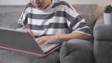 Evde dizüstü bilgisayarla çalışan 4K 'lık genç bir kadın. Ev ödevi, serbest çalışma, ev ofis işi. Kişisel karantina covid-19, Asyalı bayan müşterisine e-posta atıyor., 