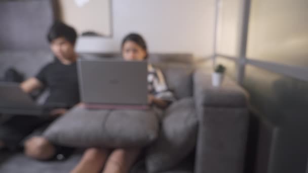 Blurは アジアのオンライン労働者が自宅の隔離中の生活 自宅での仕事 人々の開発 外の世界からの回避 社会的距離 リモート アパートのリビングルームでソファソファの上に座って撮影 — ストック動画