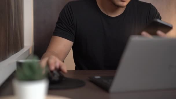 亚洲男性短信朋友工作隔离 笔记本电脑 智能手机无线连接 Covid 避免自由职业工人 温暖的夜晚 坐在家里客厅里 新的正常生活 — 图库视频影像