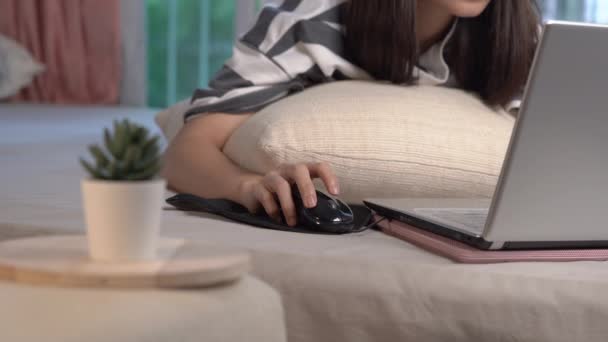 自宅で働くアジアの若い女性 自宅でベッドの上に寝そべってラップトップを使用している女の子 余暇時間 Covid 19中の家庭の隔離生活は一日中家にいます 楽しさと楽しさを — ストック動画