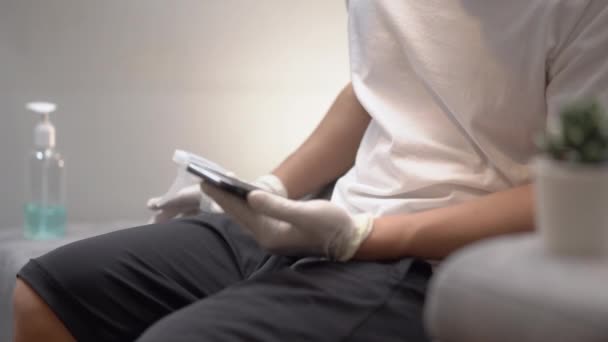 Asyalı Adam Spreyleyerek Beyaz Eldiven Dezenfekte Edici Cep Telefonu Takar — Stok video
