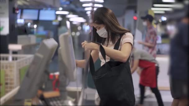 의료용 마스크를 아시아인 여성은 식료품을 슈퍼마켓 계산대에 식품을 비축하고 코로나 — 비디오