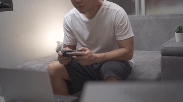 Азиатский Человек Играющий Консольные Игры Сидеть Сером Диване Гостиной Себя — стоковое видео