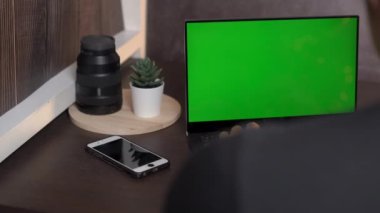 Yeşil ekranlı dizüstü bilgisayarda çalışan adam