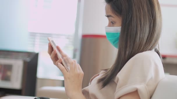 Femminile Asiatica Indossare Maschera Medica Verde Mentre Guardando Suo Smartphone — Video Stock