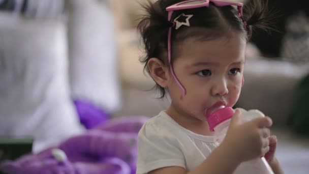 亚洲女孩手握奶瓶 独自站在家里客厅 幼儿成长 幼儿喝奶瓶中的牛奶 婴儿配方奶 家庭护理健康 养育子女 — 图库视频影像