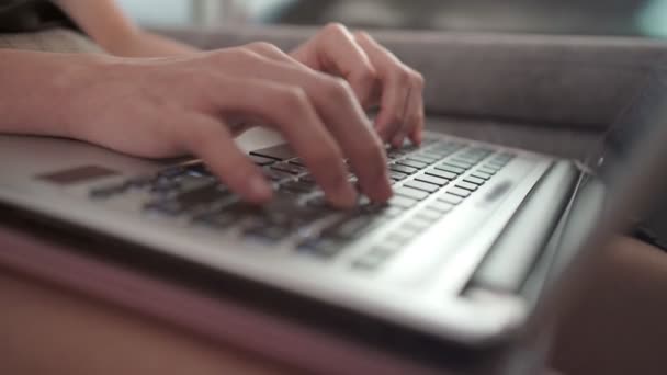 手提电脑键盘上的女性密切合作 检疫期间从家里工作的手触摸打字 坐在灰色沙发上的电晕检疫 阳光反射 在家里工作 远离工作 — 图库视频影像