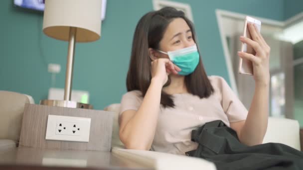 Azjatka Nosi Maskę Rozmowy Wideo Podczas Siedzenia Kanapie Przez Smartfon — Wideo stockowe