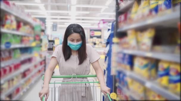 아시아의 청년들은 마스크를 착용하고 여성들은 카메라를 여성들은 식료품 점에서 카트를 — 비디오