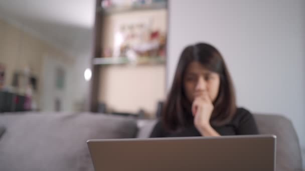 Θολό Υπόβαθρο Ασιάτισσα Εργαζόμενη Γυναίκα Κάθεται Στον Καναπέ Φορητό Υπολογιστή — Αρχείο Βίντεο