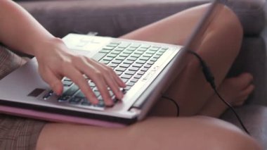 Asyalı çalışan kadın dizüstü bilgisayarla oturuyor, oturma odasında kanepeye oturuyor, projesi üzerinde çalışıyor, ev karantinası, karar verme, ekonomik kriz, iş fırsatı, öz disiplin